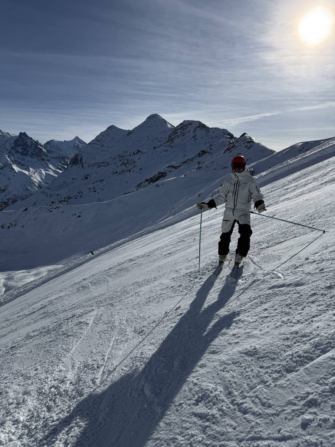 Luc Guillot à ski devant un panorama de sommets enneigés